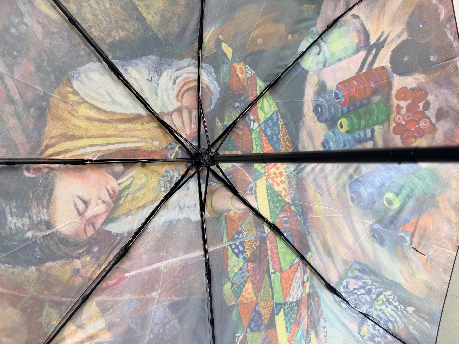 Vista desde debajo del paraguas artístico terminado que muestra la escena impresa y la estructura